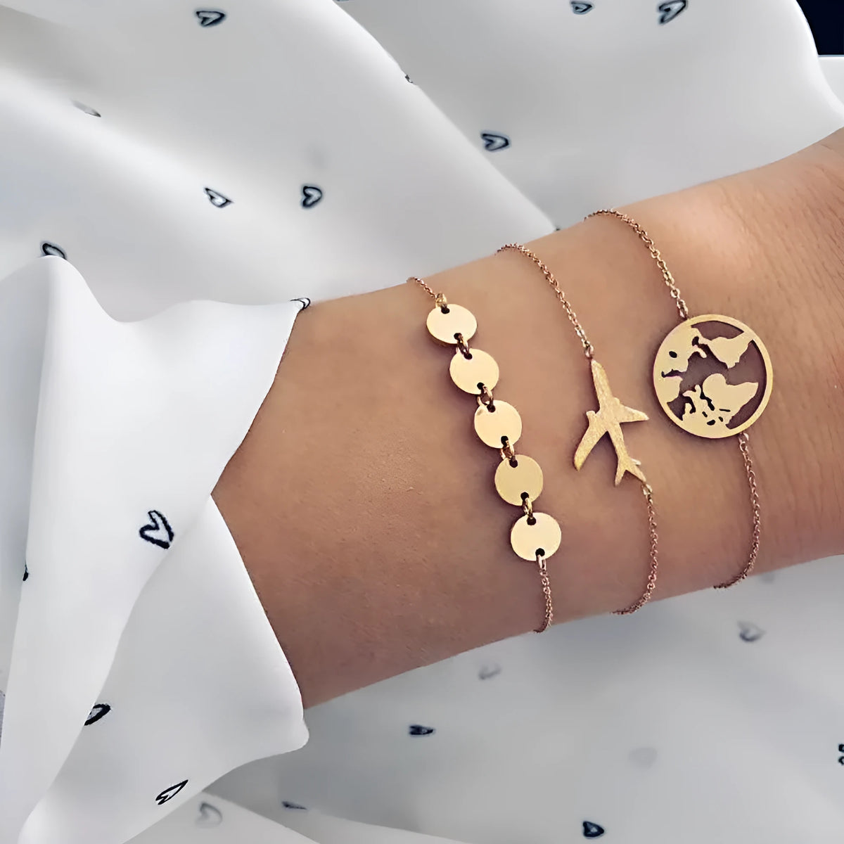 Three Bohemian-style bracelets with aircraft map and heart charms in gold electroplated finish