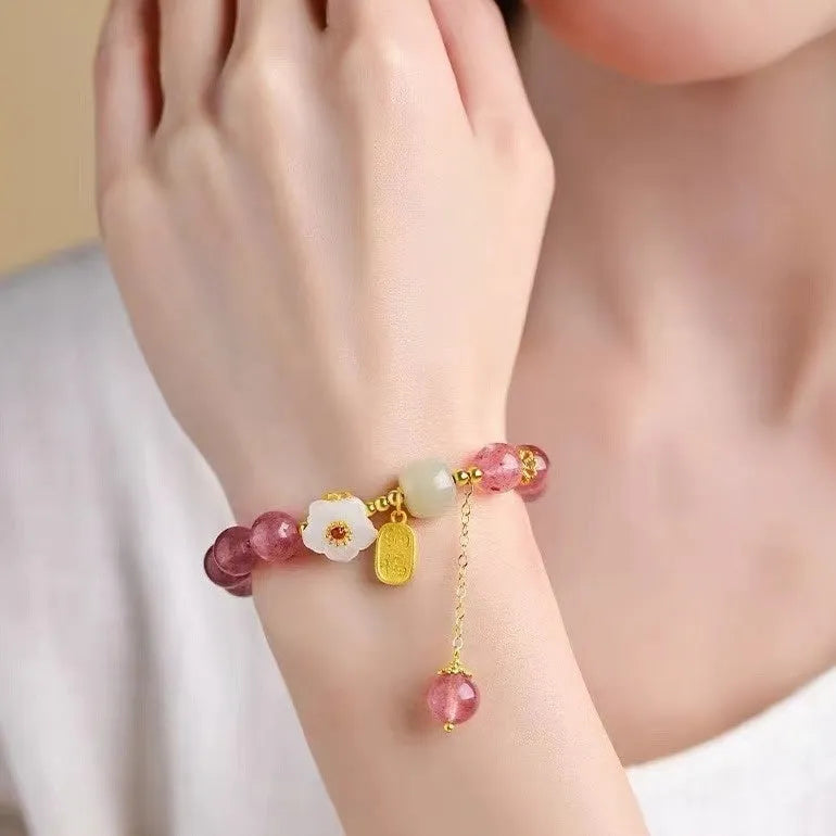 Handmade women's strawberry quartz crystal bracelet with pearl, moon, and XINGX designs