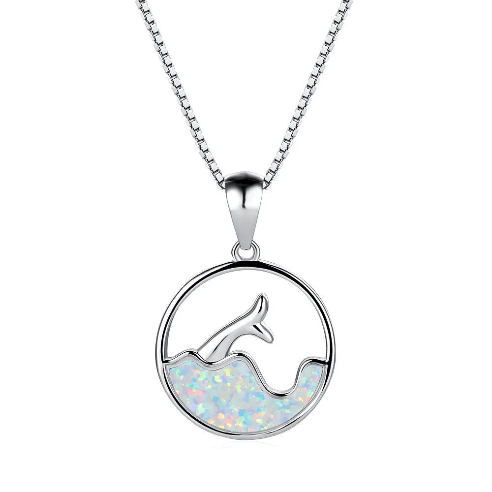 Close-up of a white gold electroplated geometric sea fishtail round pendant necklace on a model.