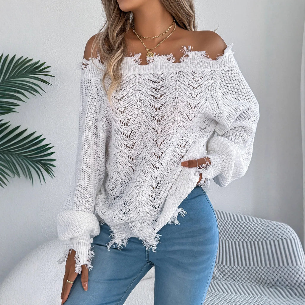 White hollow-out cut off-the-shoulder long sleeve pullover sweater on a hanger showing acrylic knit fabric detail.