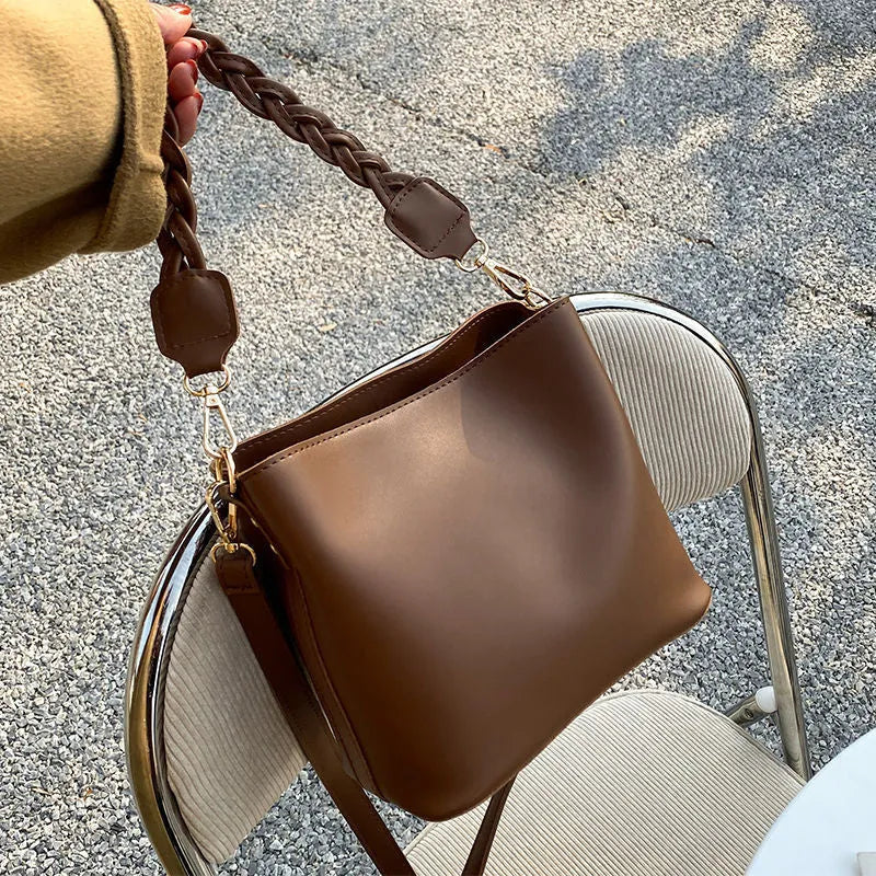 Retro woven crossbody bucket bag in khaki colour showing one-shoulder strap and textured PU material.