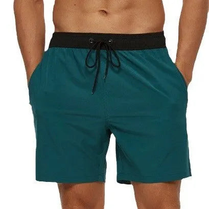 Men's blue drawstring fitness shorts with side pocket and stitching detail on the waistband.