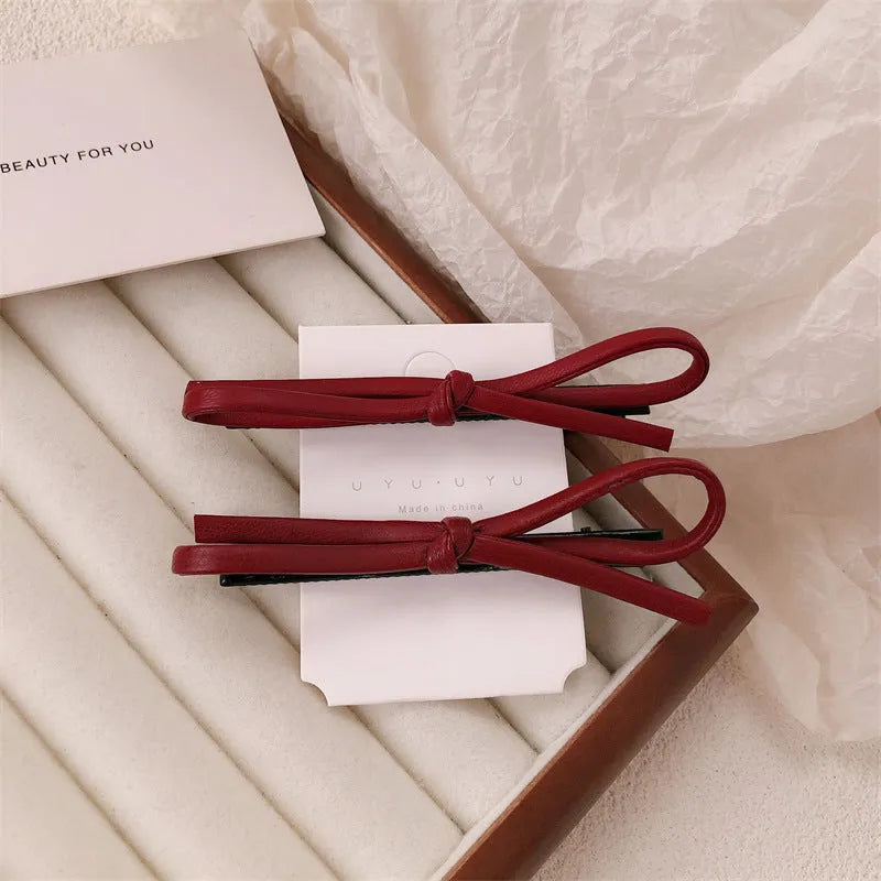 Wine red leather bow hair barrette showing manual craftsmanship and bow design details