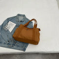 Women's solid colour canvas shoulder bag showing interior mobile phone compartment and exterior sandwich pocket