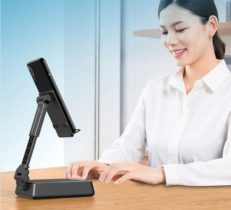 Black mobile phone broadcast stand with integrated Bluetooth speaker and microphone on a desk.