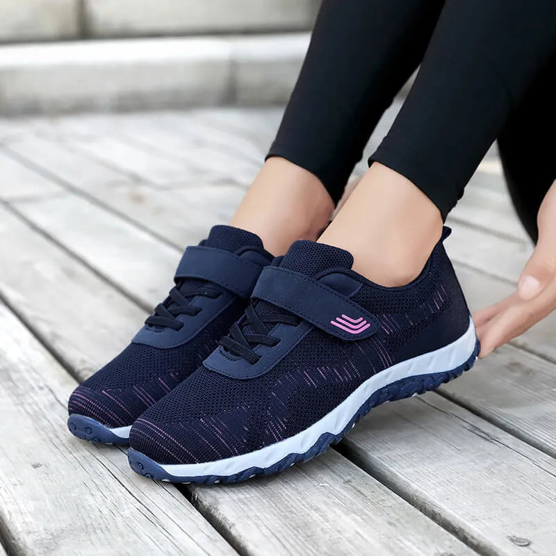 Grey purple women's low-top shoes with a velcro strap and wedge sole on a white background.