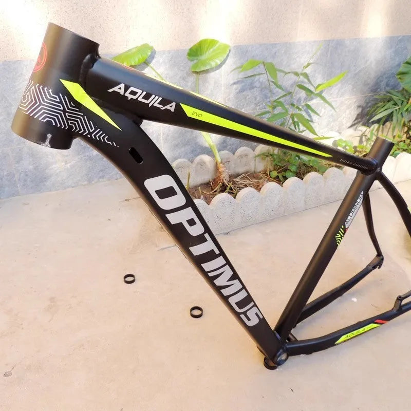 Black green aluminium 29-inch mountain bike frame showing disc brake mount and internal cable routing ports.