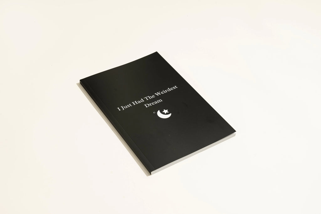 Black hardcover dream journal notebook with blank interior pages.