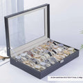 Grey leather watch storage box with clear dustproof lid showing watch cushions inside