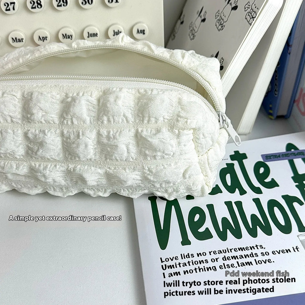 Fabric cream puff style pencil case in polyester material showing beige and black colour options