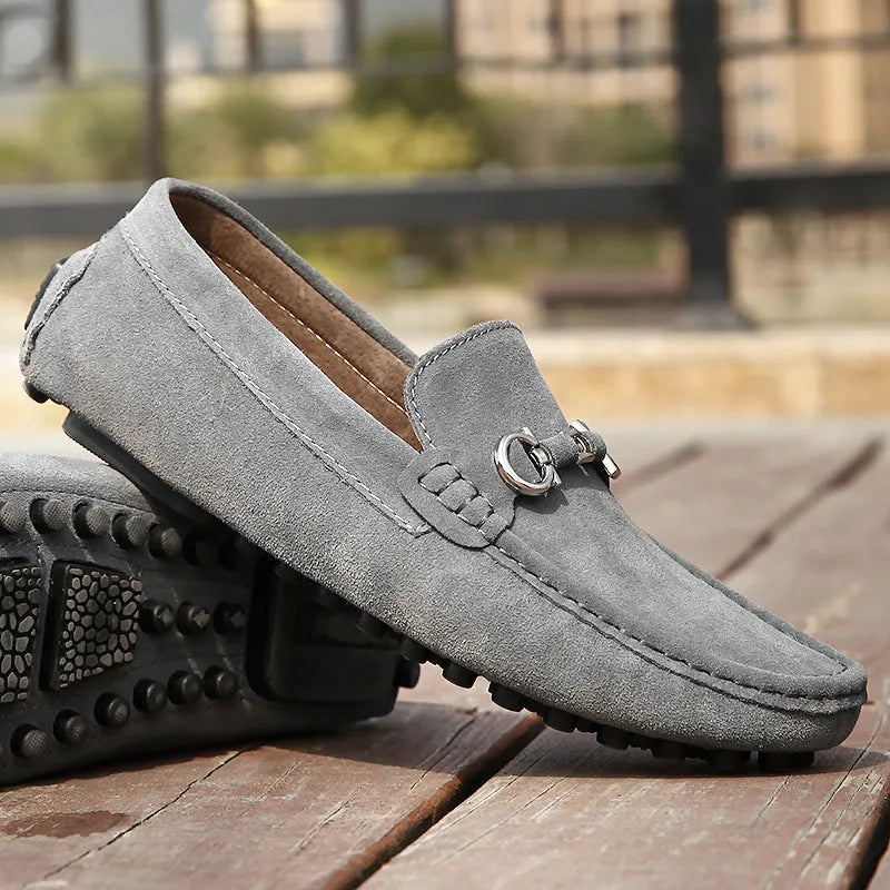 Men's black slip-on leather shoes with a square toe and matte finish on a plain background.
