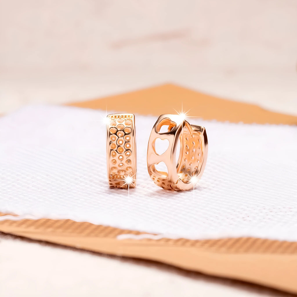 Rose gold electroplated drop earrings with three hollowed-out hearts in a circular arrangement.