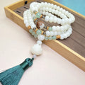 Close-up of a white jade Bodhi bead bracelet with 108 beads, showing different style patterns.