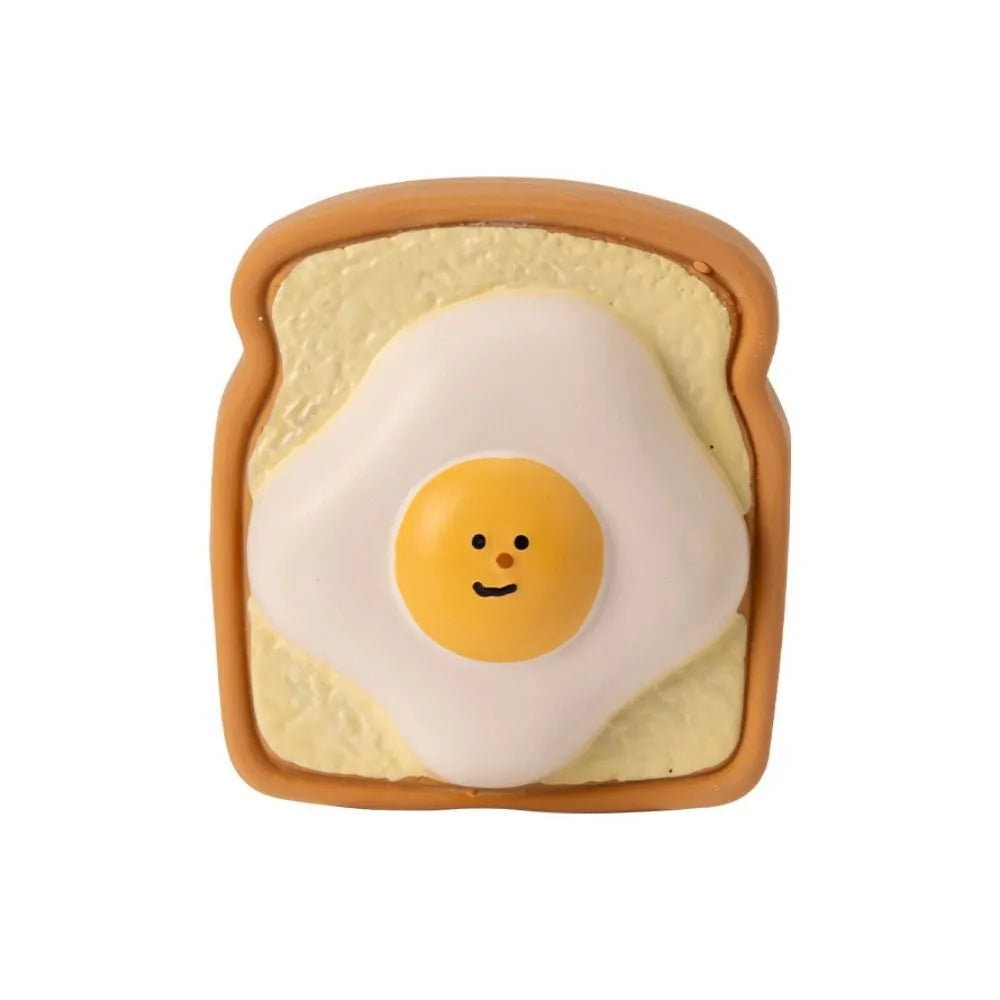 Yellow and green cartoon egg bread shaped latex squeaky toy for dogs on a white background.