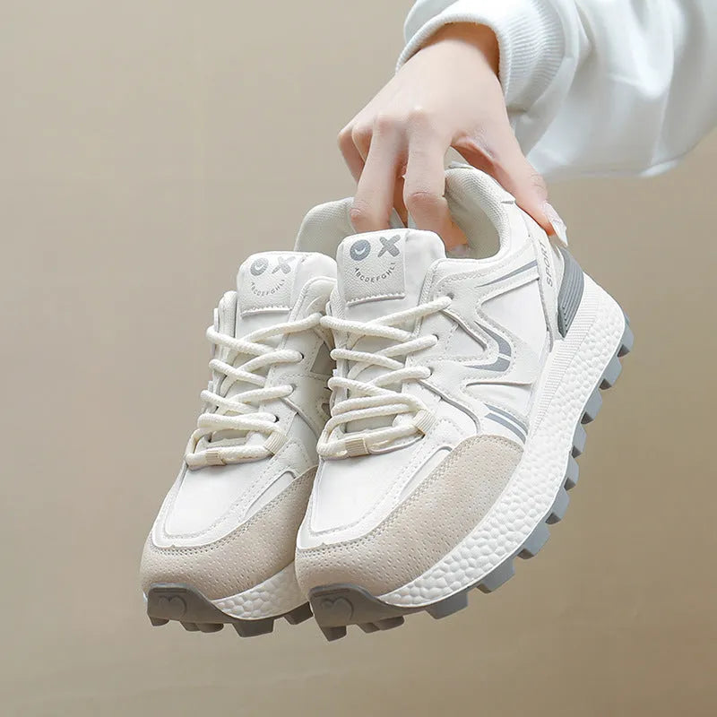 Women's black platform casual sports shoes with flat heel and white lace-up front closure on a neutral background.