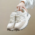 Women's black platform casual sports shoes with flat heel and white lace-up front closure on a neutral background.