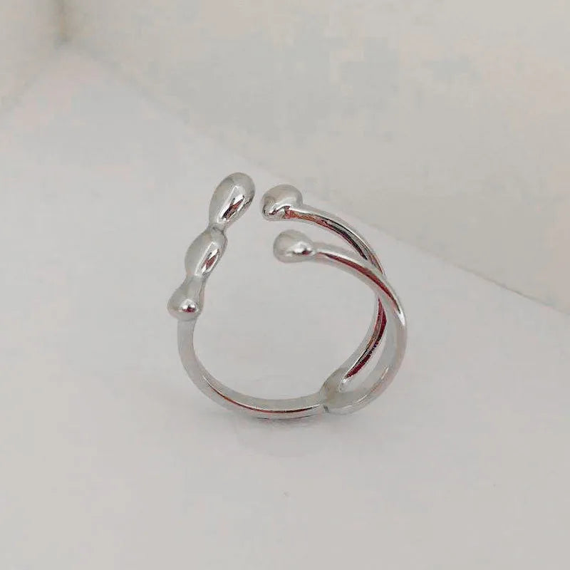 Adjustable brass opening ring with spherical detail in gold or silver colour
