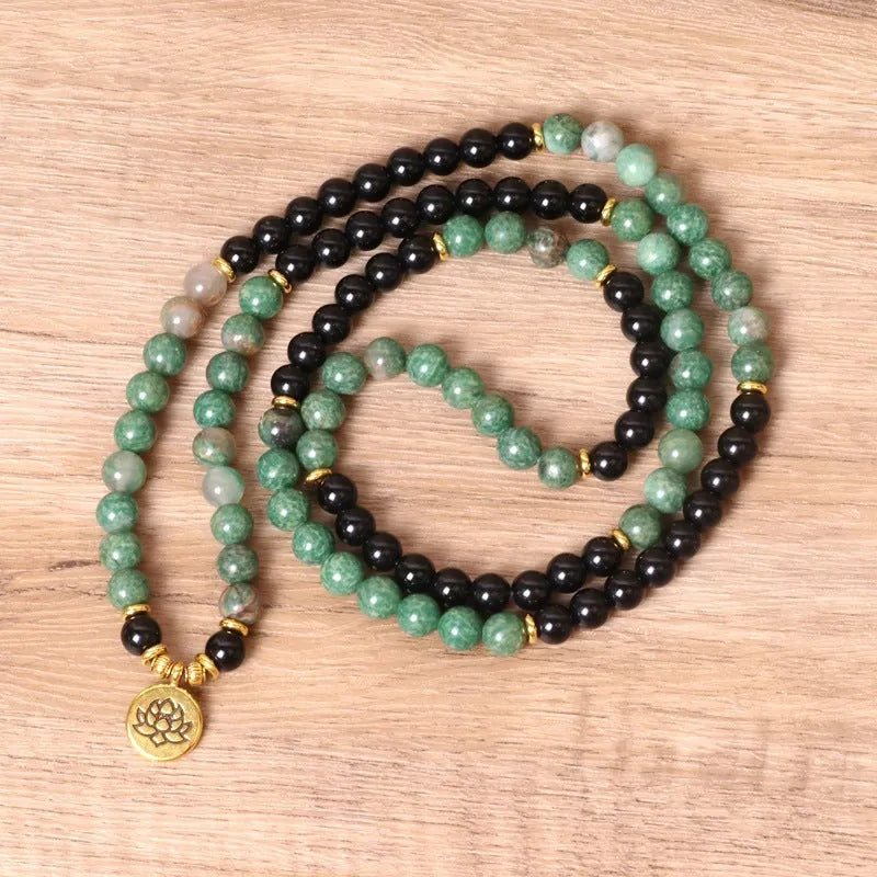Green and black alloy bead elastic bracelet on wrist showing adjustable stretch design