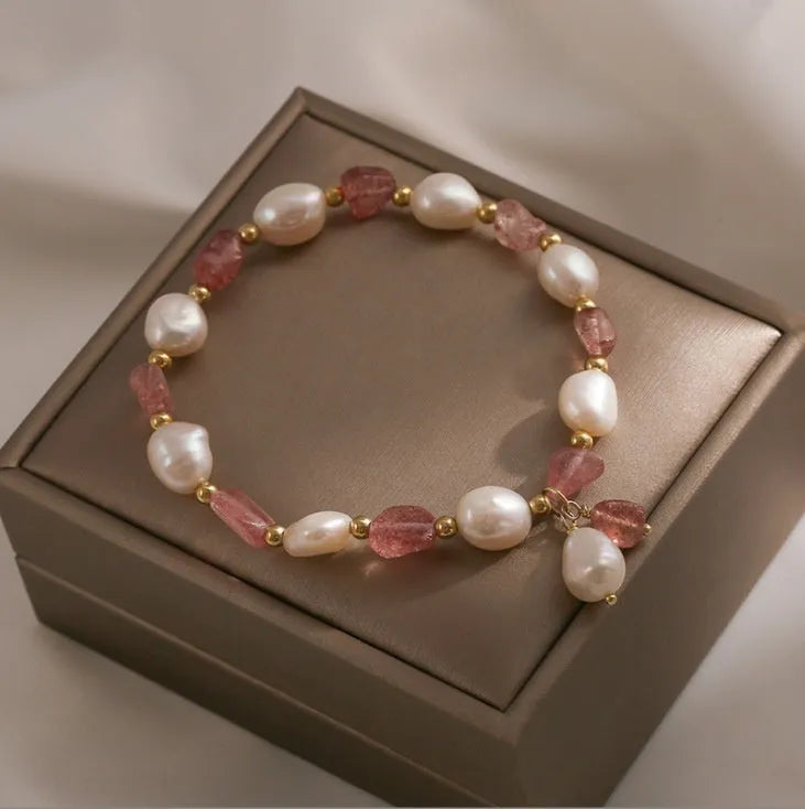 Handmade women's strawberry quartz crystal bracelet with pearl, moon, and XINGX designs