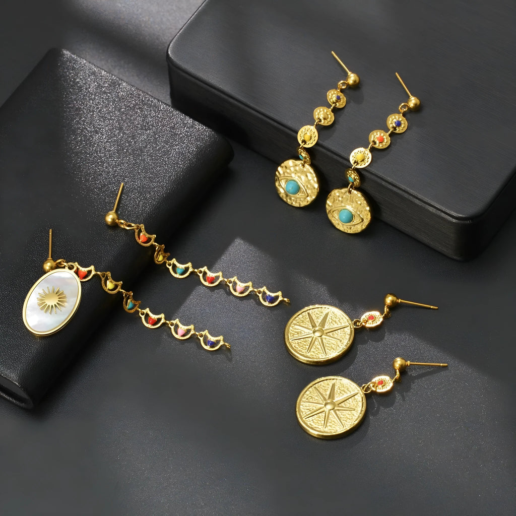 Geometric stainless steel earrings showing eight awn star, eye pattern, and shell sun designs