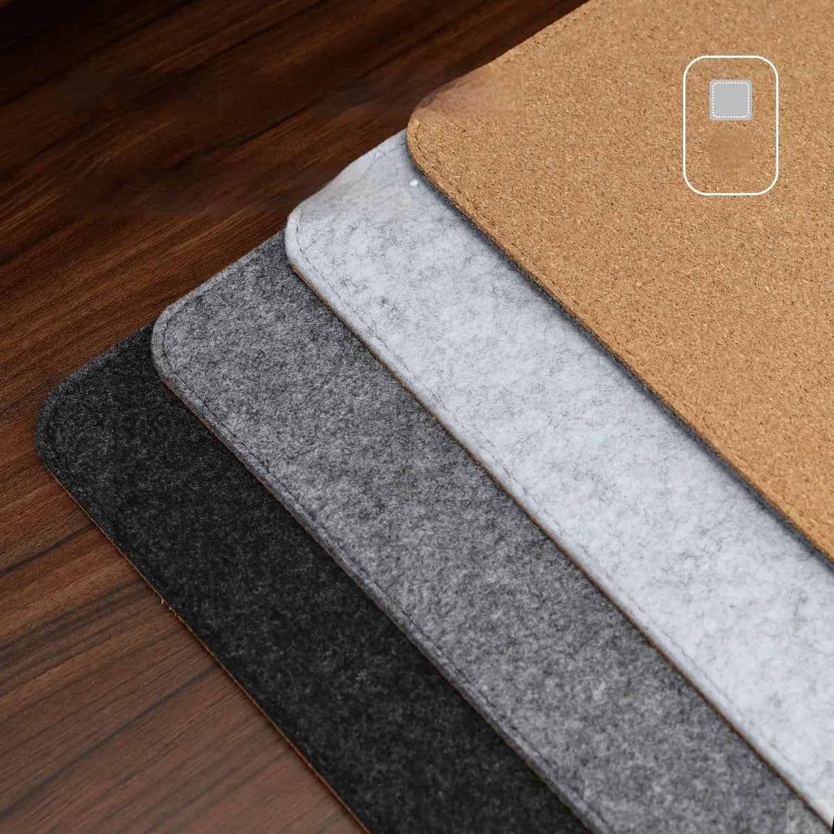 Grey and black felt cork office mouse pad on a wooden desk