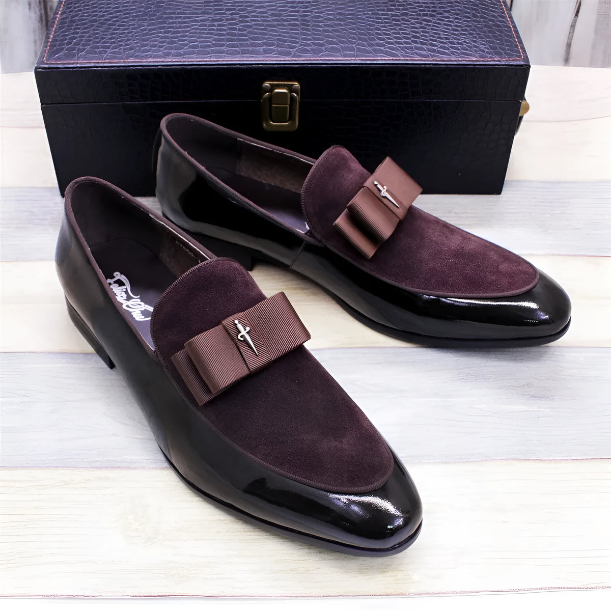 Men's low-top leather shoes in black with patent leather finish and a tassel detail.
