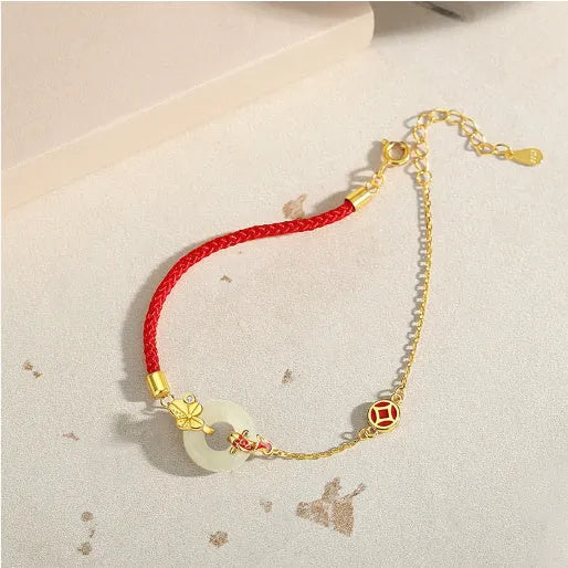 Women's silver bracelet with gold koi design and red rope adjustment