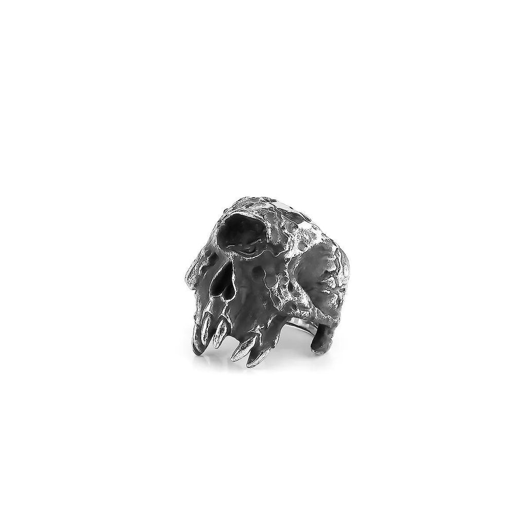 Alloy ring with a detailed one-eyed skull design on a finger, showing its metallic retro finish.