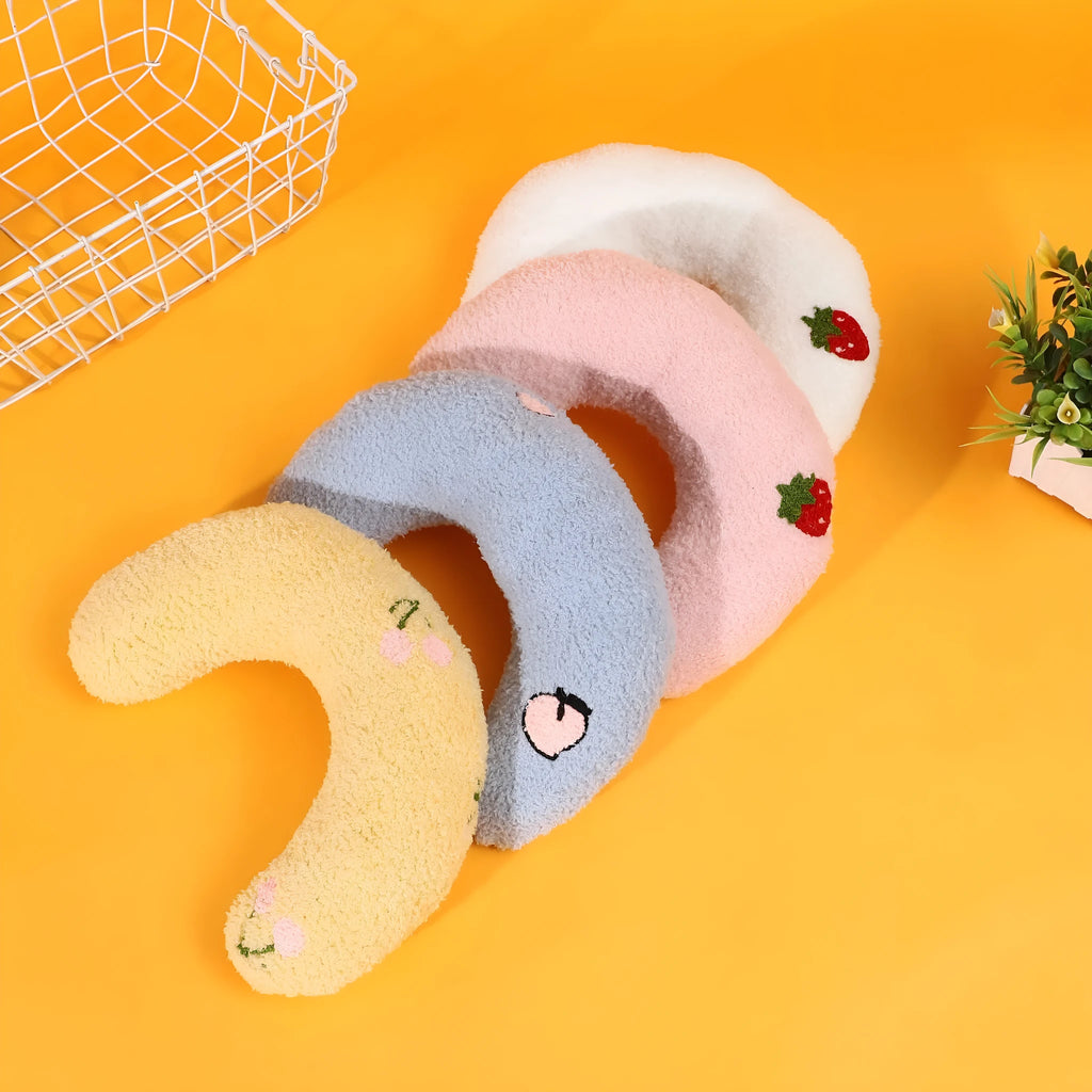Colourful cartoon half moon shaped cloth pillow for cats and dogs on a neutral background.