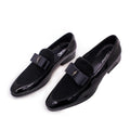 Men's low-top leather shoes in black with patent leather finish and a tassel detail.