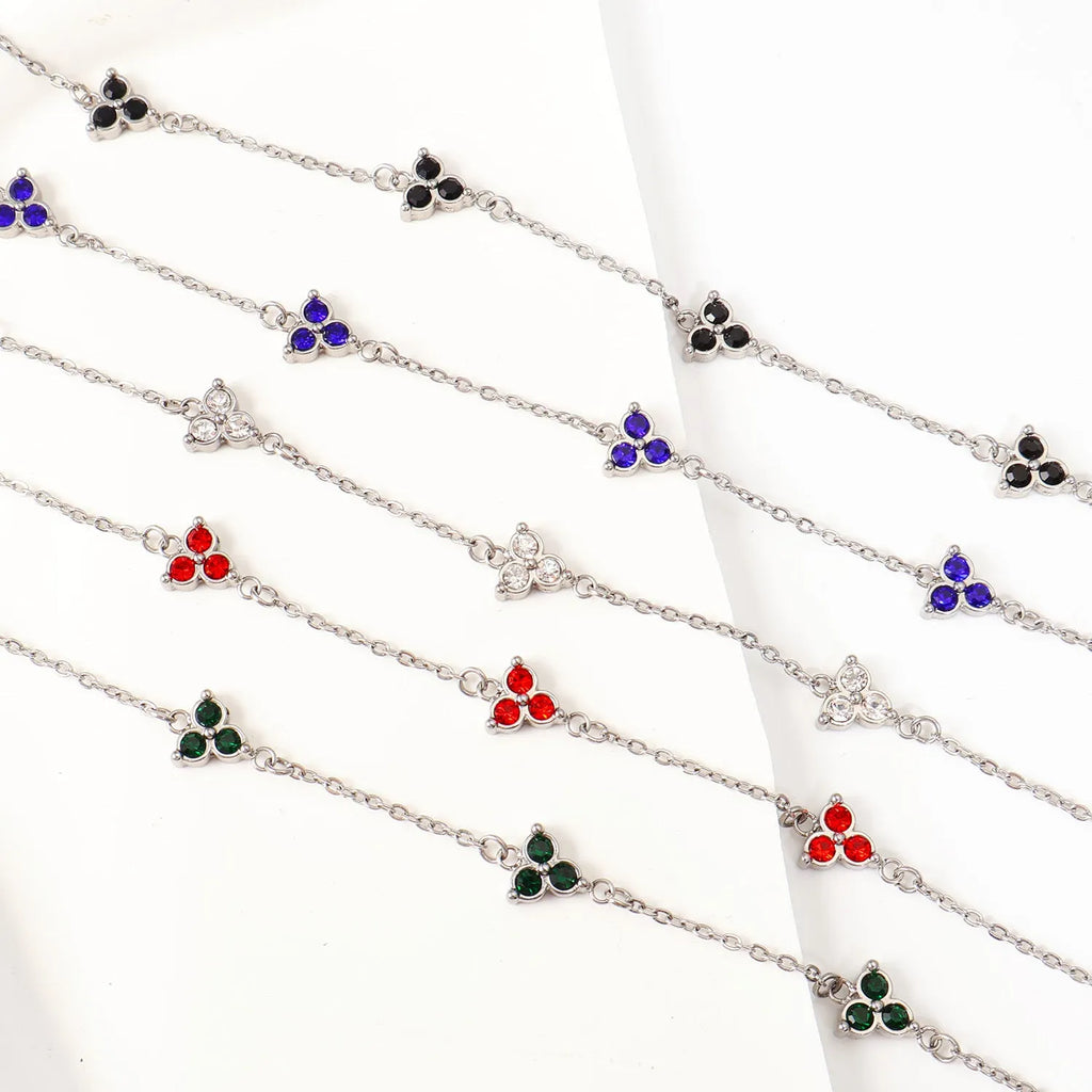 Women's stainless steel geometric bracelet with three diamonds and a coloured zircon stone in a triangular setting.
