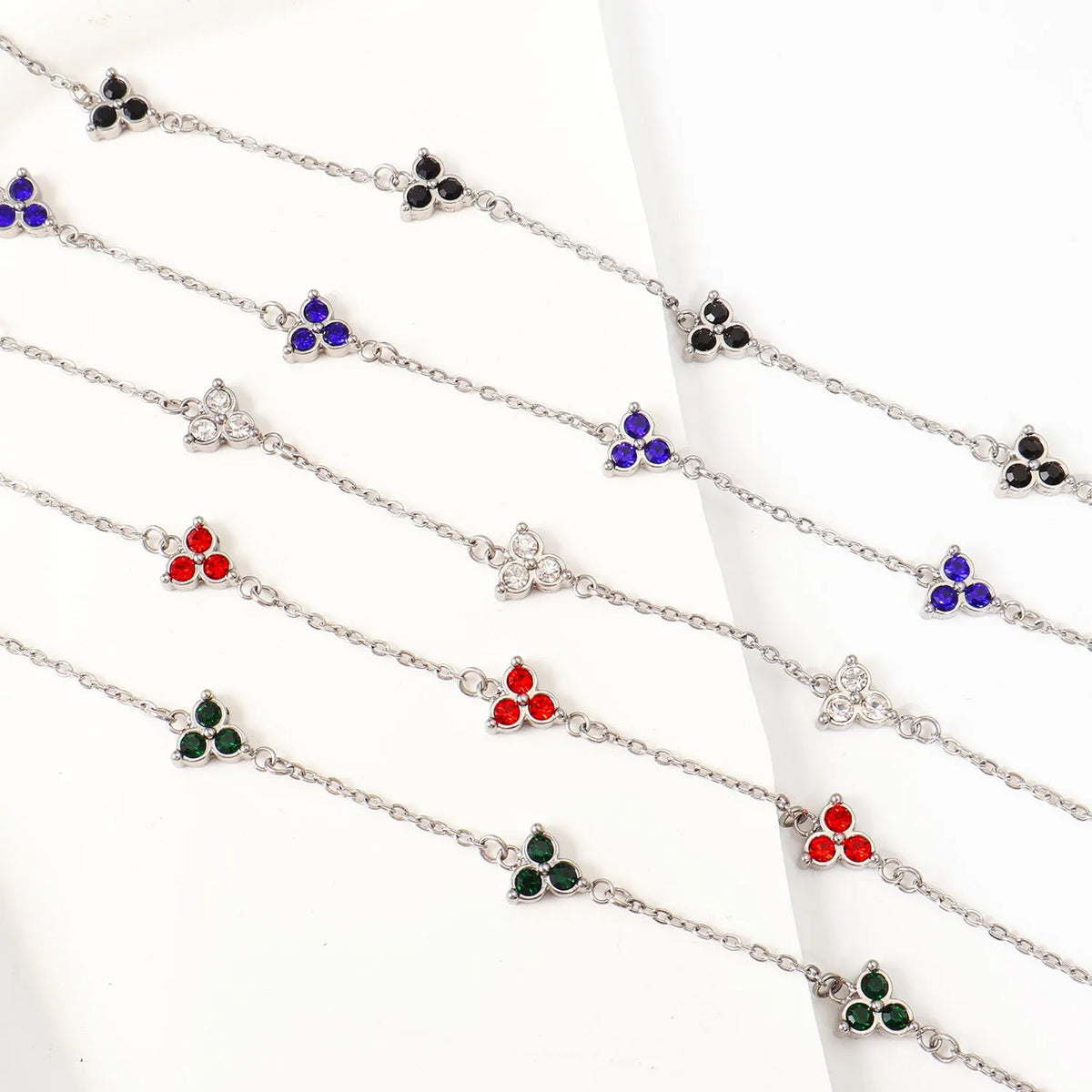 Women's stainless steel geometric bracelet with three diamonds and a coloured zircon stone in a triangular setting.