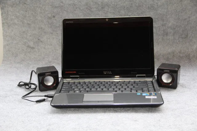 Black square USB-powered 2.0 computer speaker on desk with single cable connection