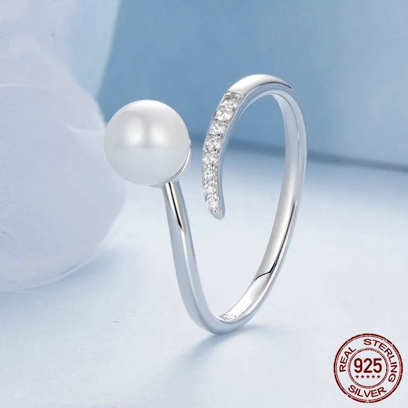 Adjustable open loop S925 sterling silver ring decorated with white shell pearls.