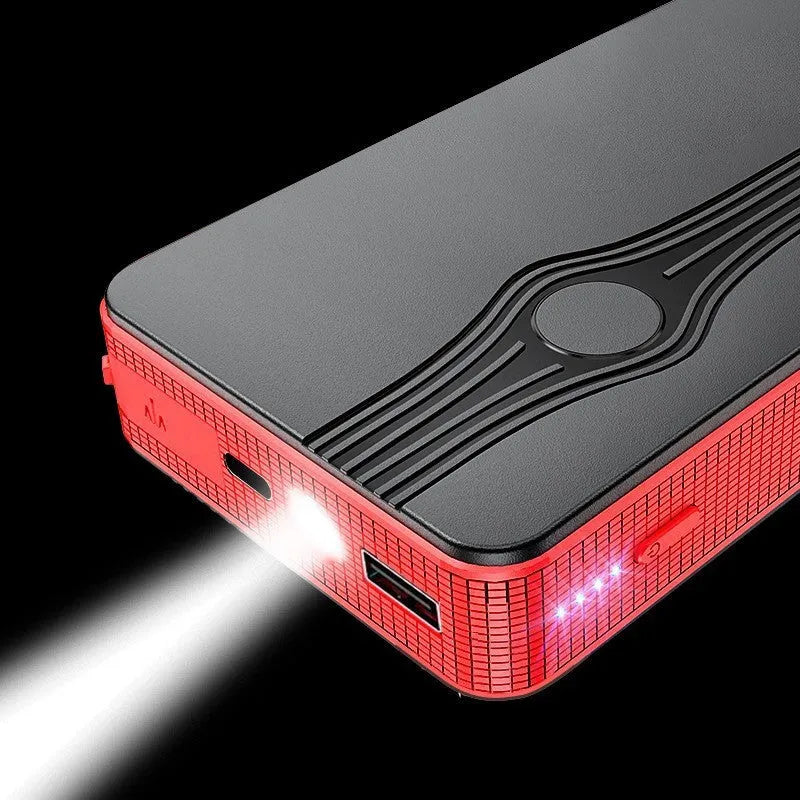 Red K4-E automobile emergency starting power supply unit with a data cable on a surface.