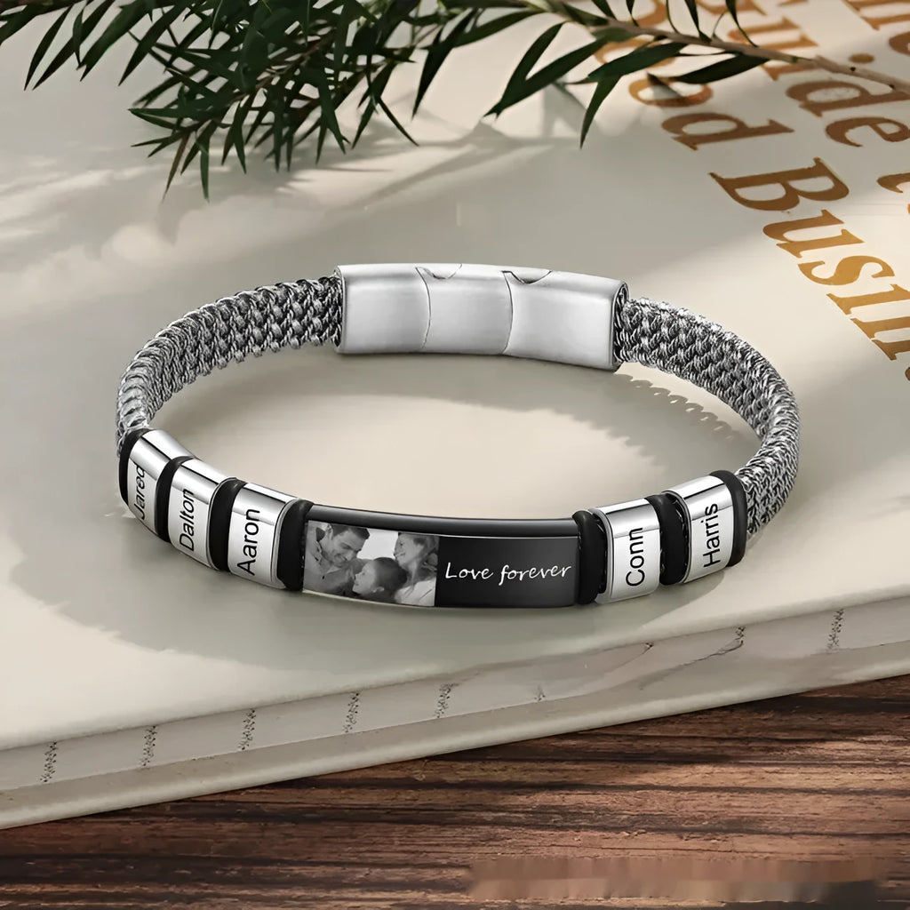 Men's stainless steel lettering bracelet with heart-shaped engraved beads on an adjustable brown leather rope strap.