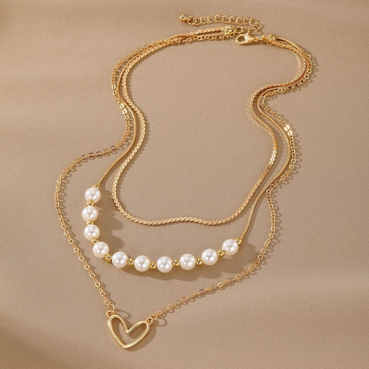 Vintage gold necklace with heart-shaped pendant and pearl chain design