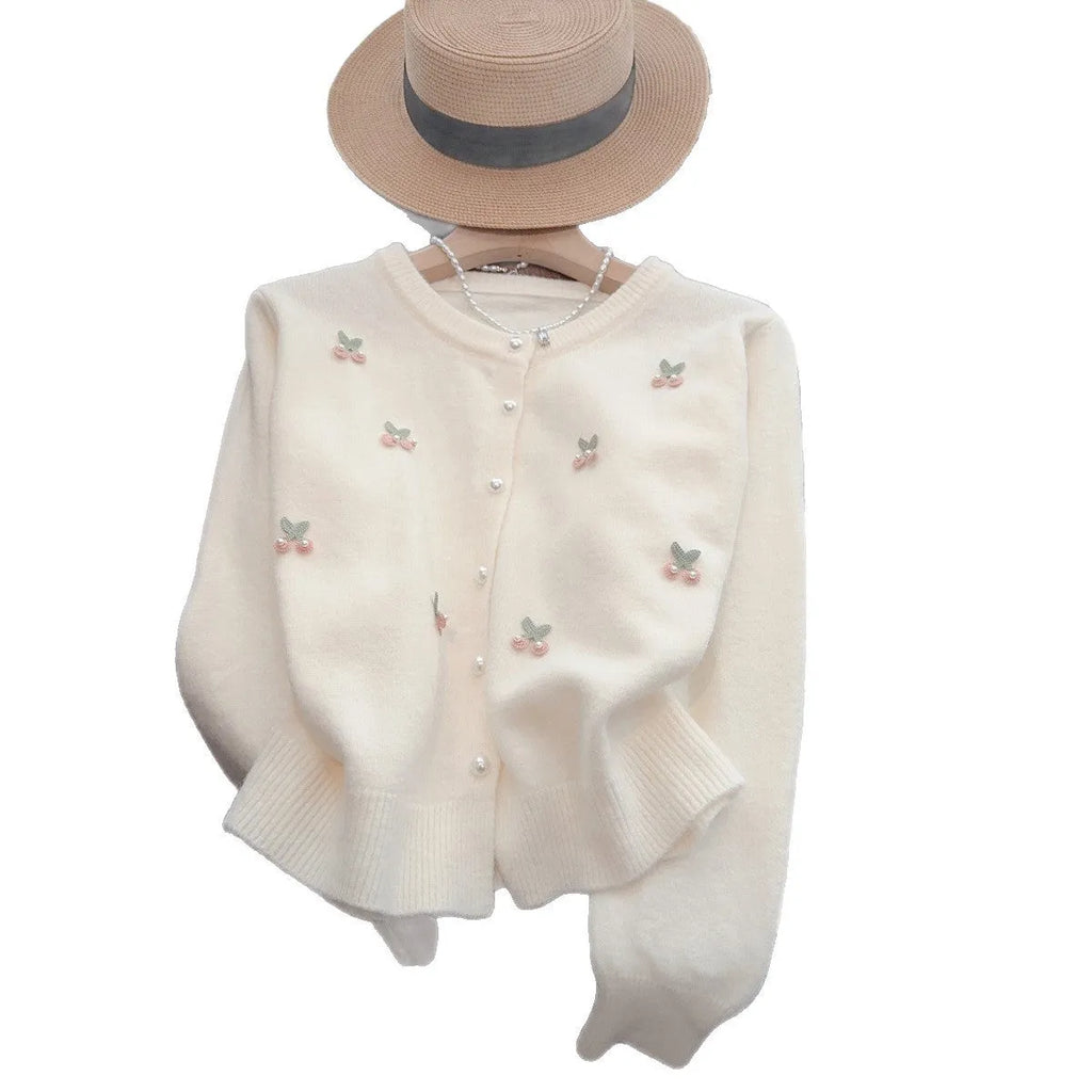 A pink cashmere blend ladies cardigan with beaded details, shown on a hanger.