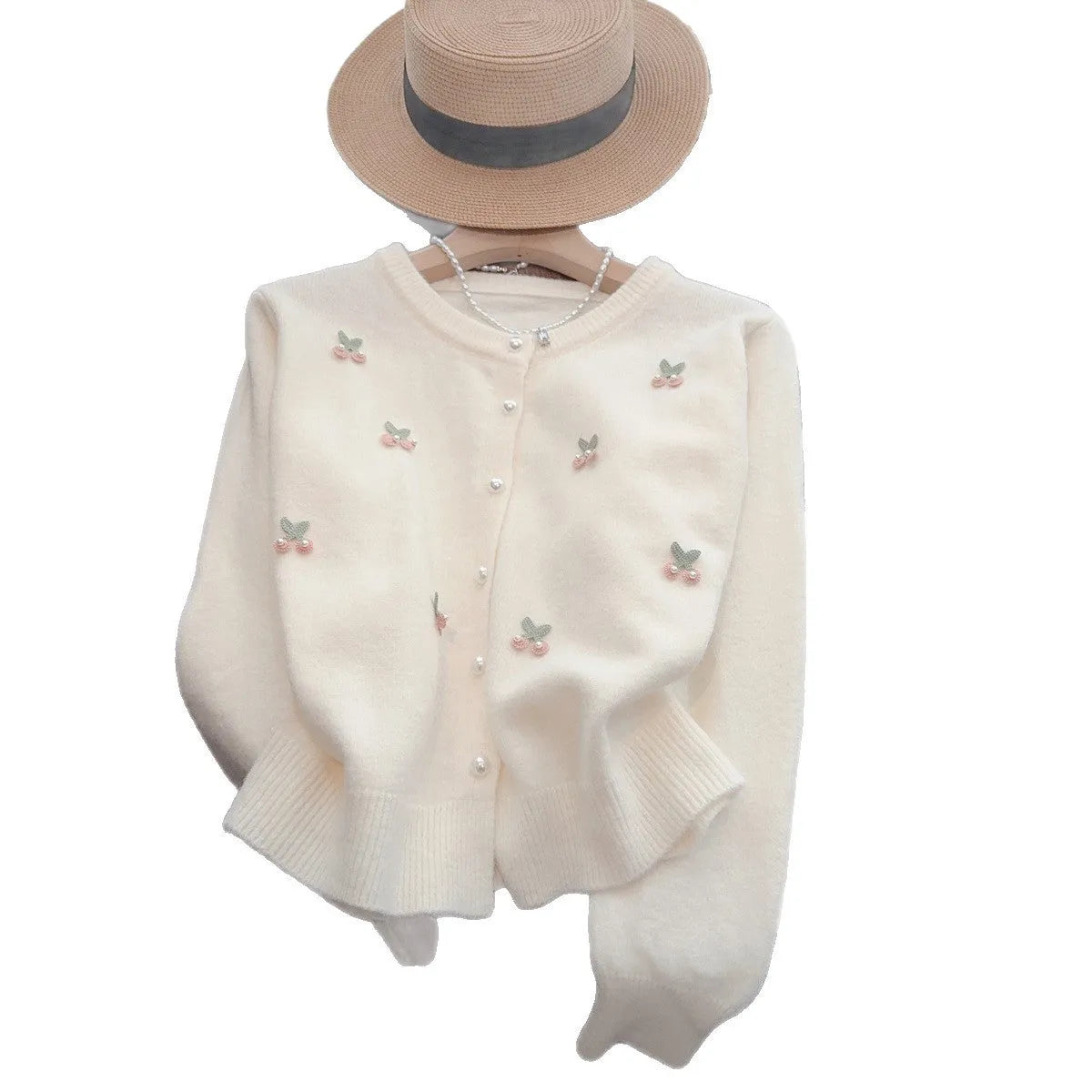 A pink cashmere blend ladies cardigan with beaded details, shown on a hanger.