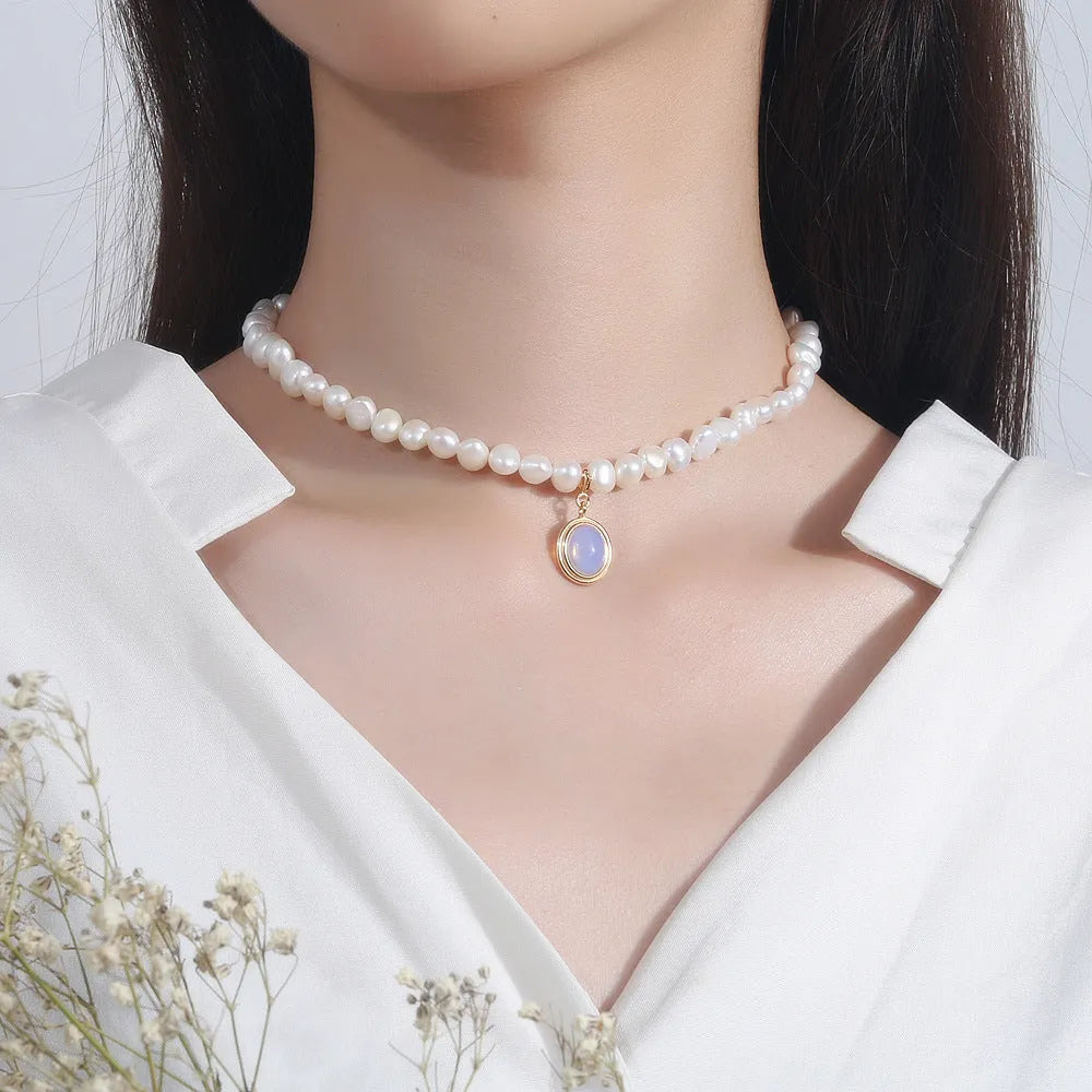 White geometric sterling silver pendant necklace with an irregular pearl on an adjustable chain.