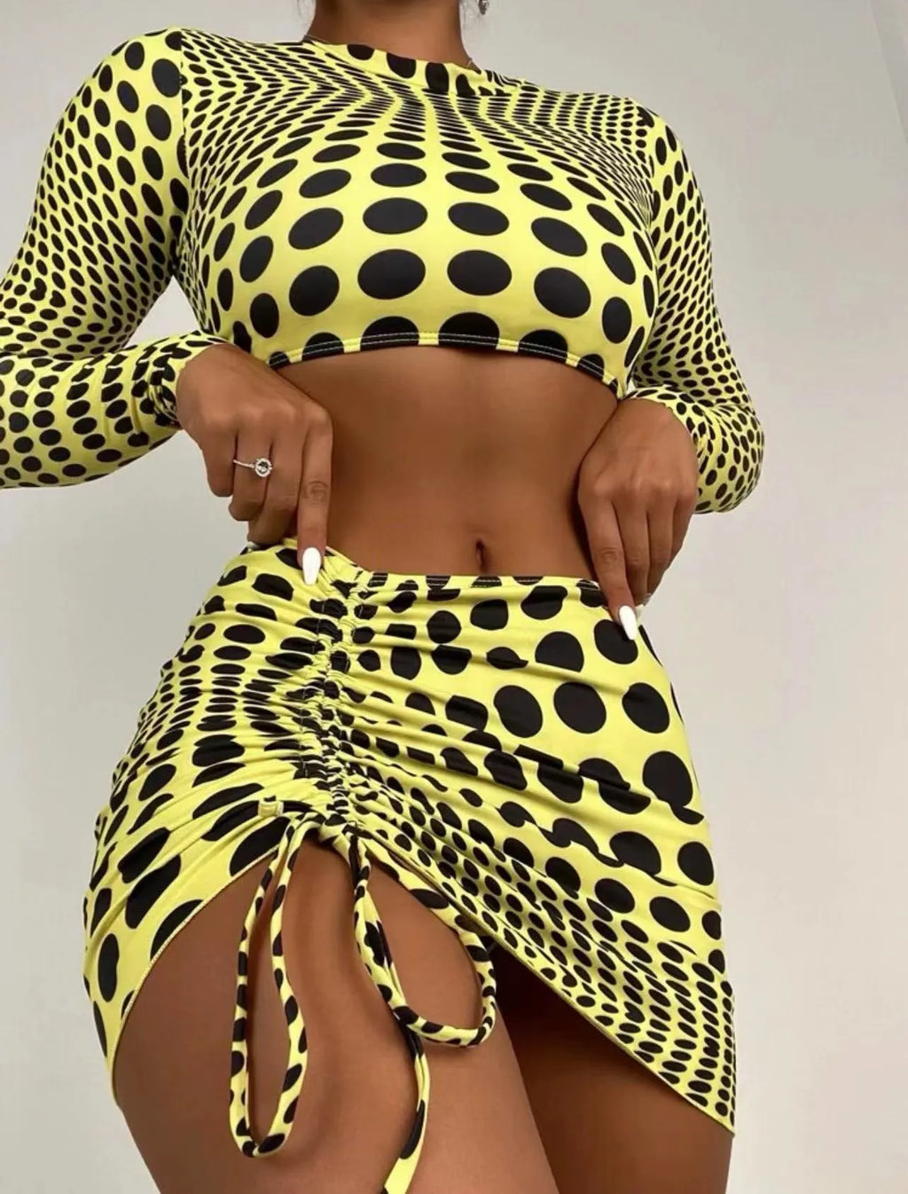 Women's green polka dot swimsuit three-piece set with bra, top and skirt on hanger