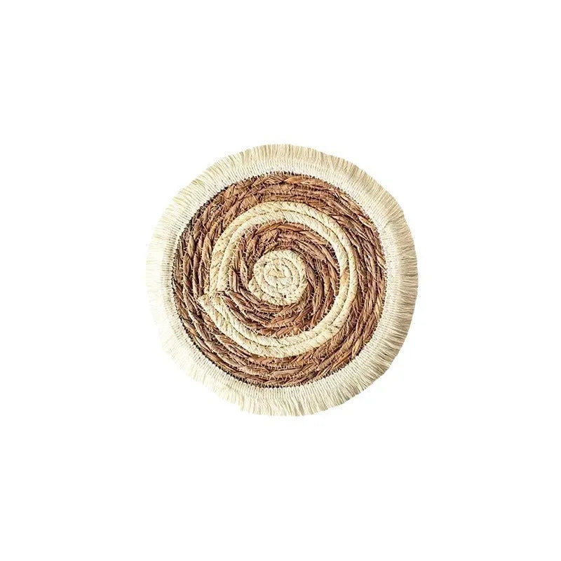 Round Japanese straw placemat with tassel edge on wooden table