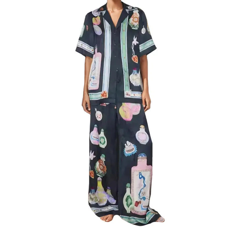 Black women's cardigan and pants set with cartoon animation pattern, laid flat.