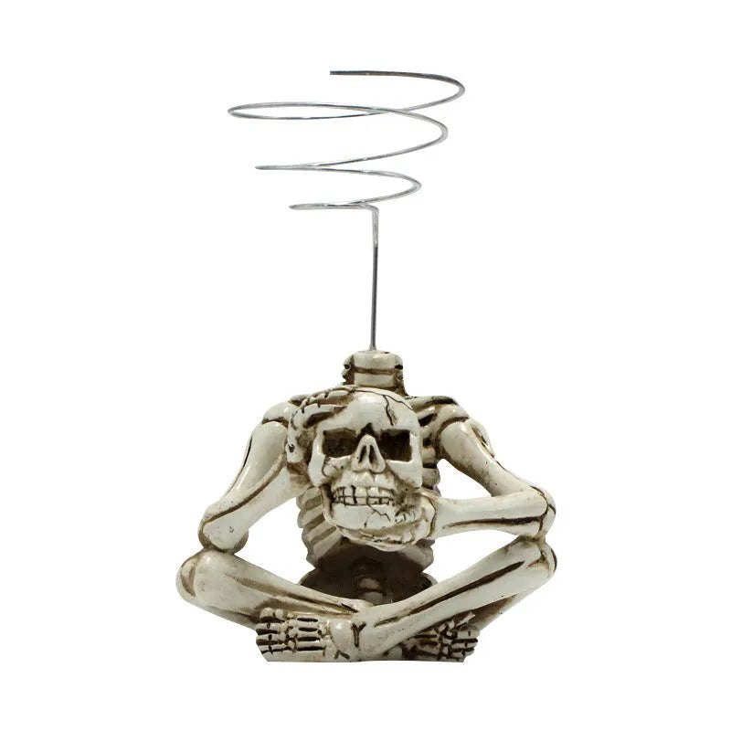 Gothic resin skull bracket holding a Tillandsia air plant, showing detailed skull ornament and layered construction.