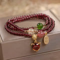Purplish red garnet fox charm bracelet on an adjustable rope for women.