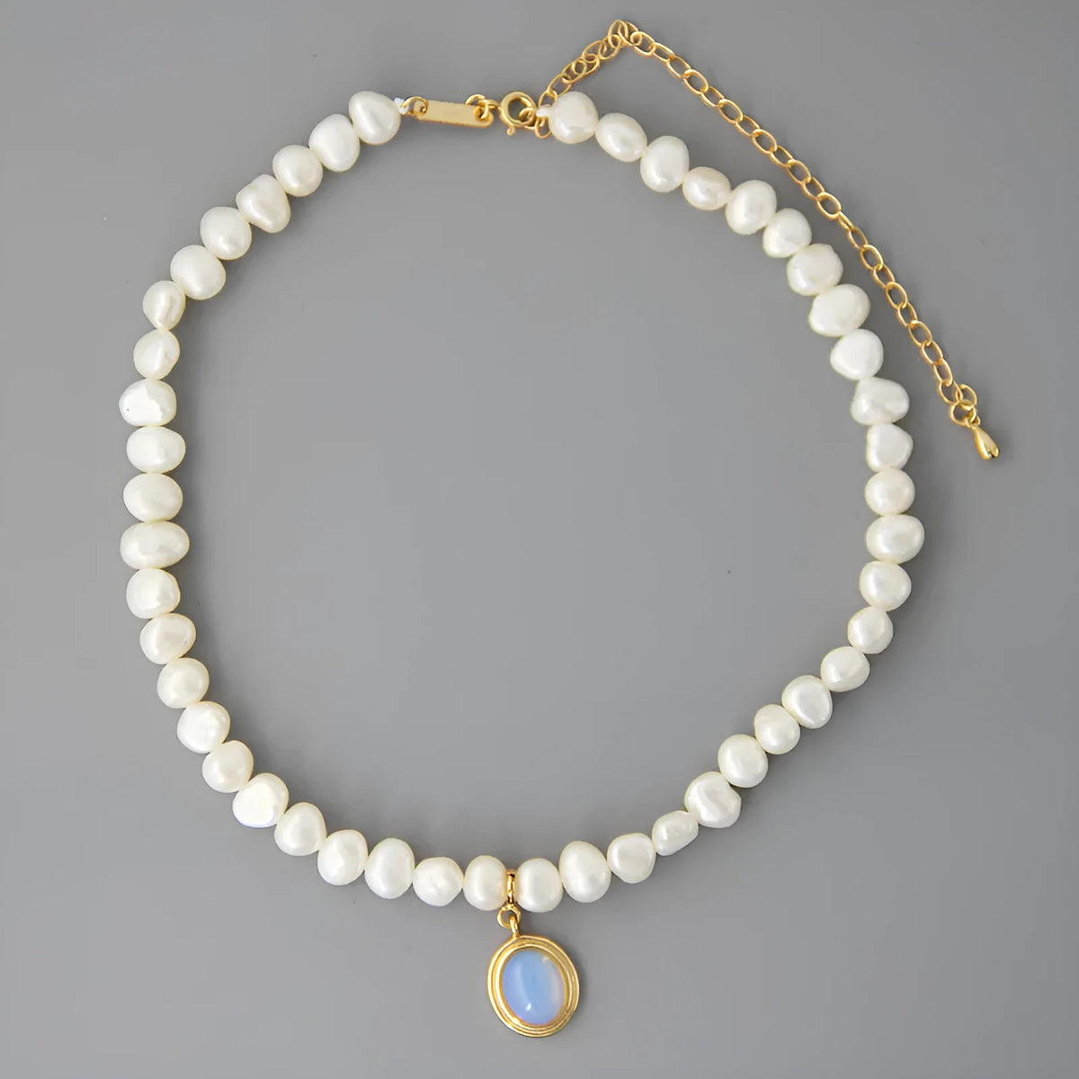 White geometric sterling silver pendant necklace with an irregular pearl on an adjustable chain.