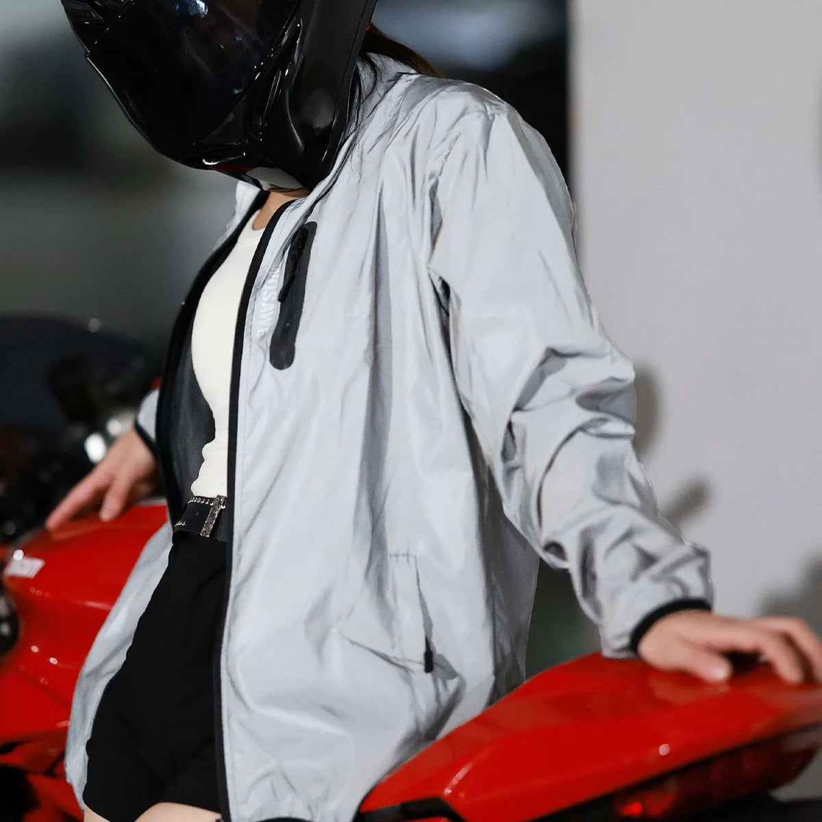 Silver waterproof polyester long sleeved jacket with front zip, shown on a hanger.