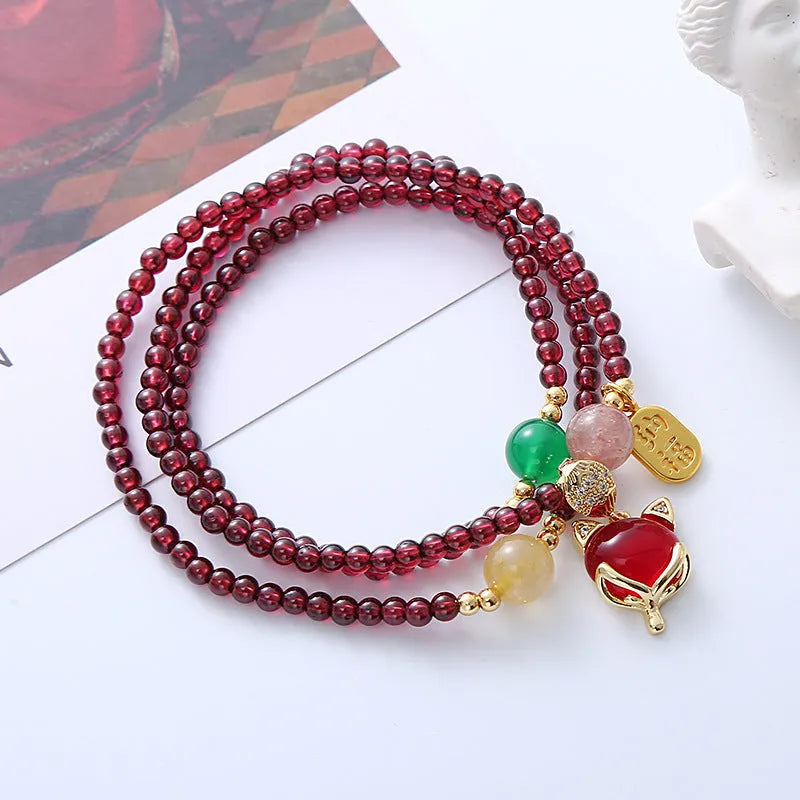 Purplish red garnet fox charm bracelet on an adjustable rope for women.