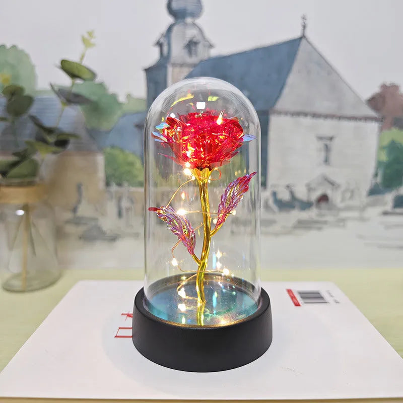Small 15cm tall night lamp with glass cover and plastic flower base on black stand.