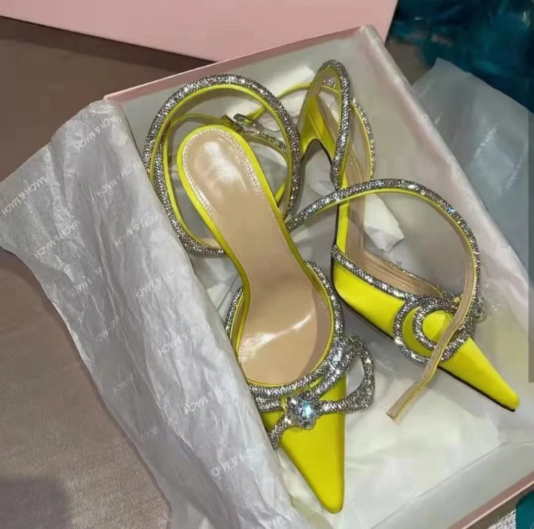 Women's black stiletto heel sandals with a silk bandage wrap back and buckle fastening, showing pointed toe.